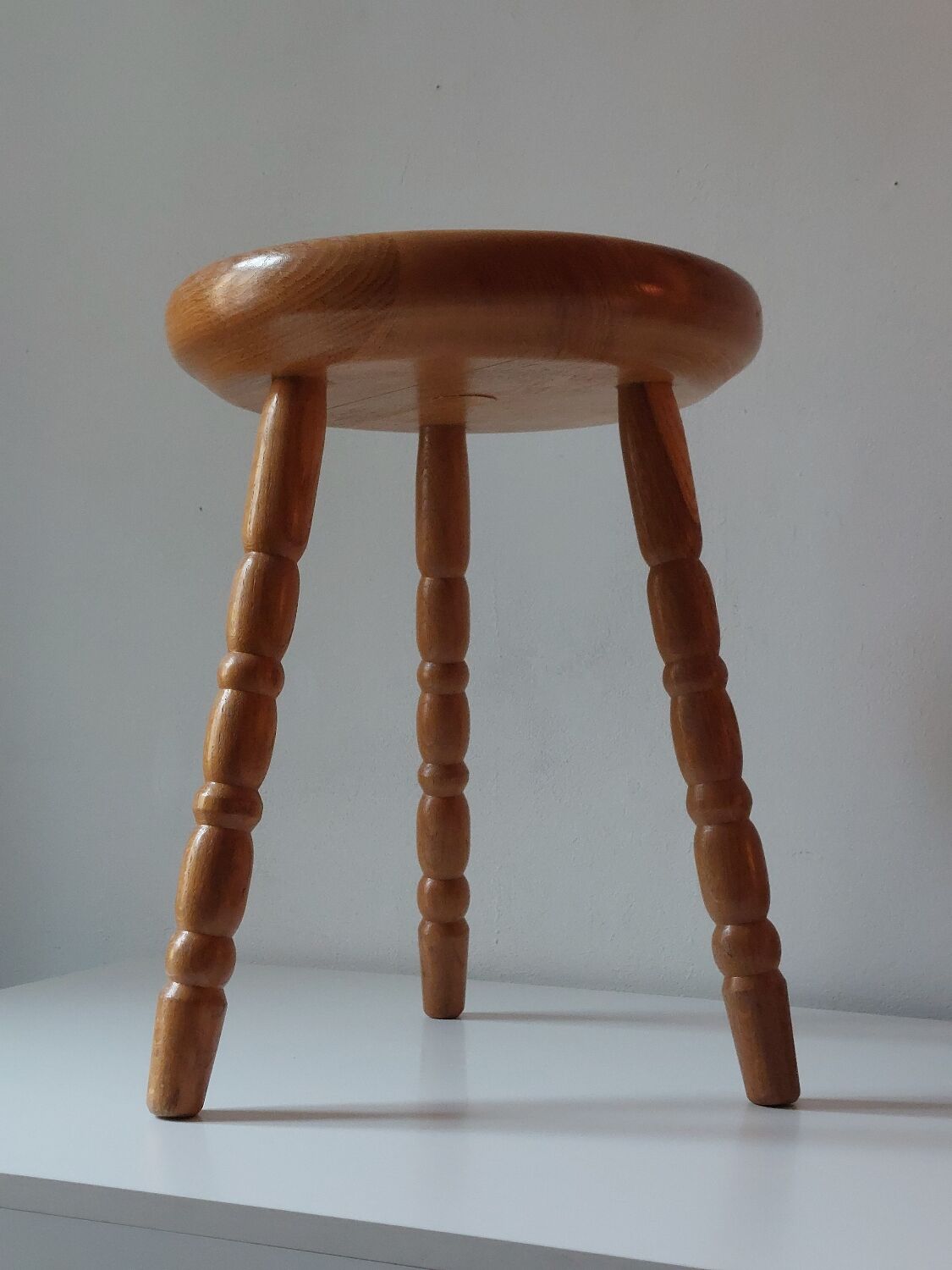 Vintage en bois tourné tabouret du milieu du siècle avec un siège épais.