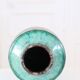 Chinese glazed earthenware vase with bird and flower decoration on a green background