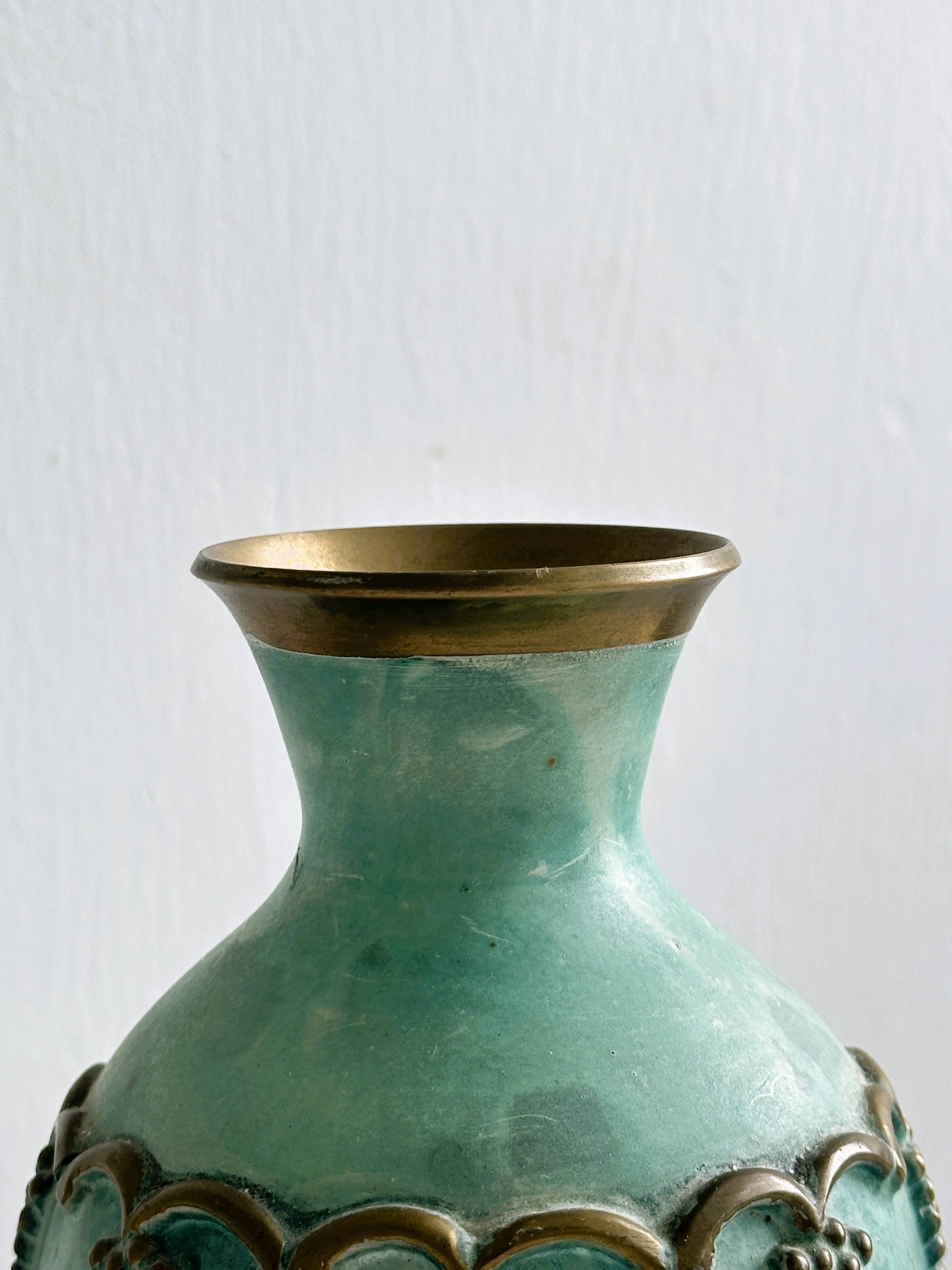 Brass vase decorated with bunches of grapes.