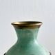 Brass vase decorated with bunches of grapes.