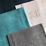 Set of four old damasked and monogrammed napkins, dyed in multiple colors