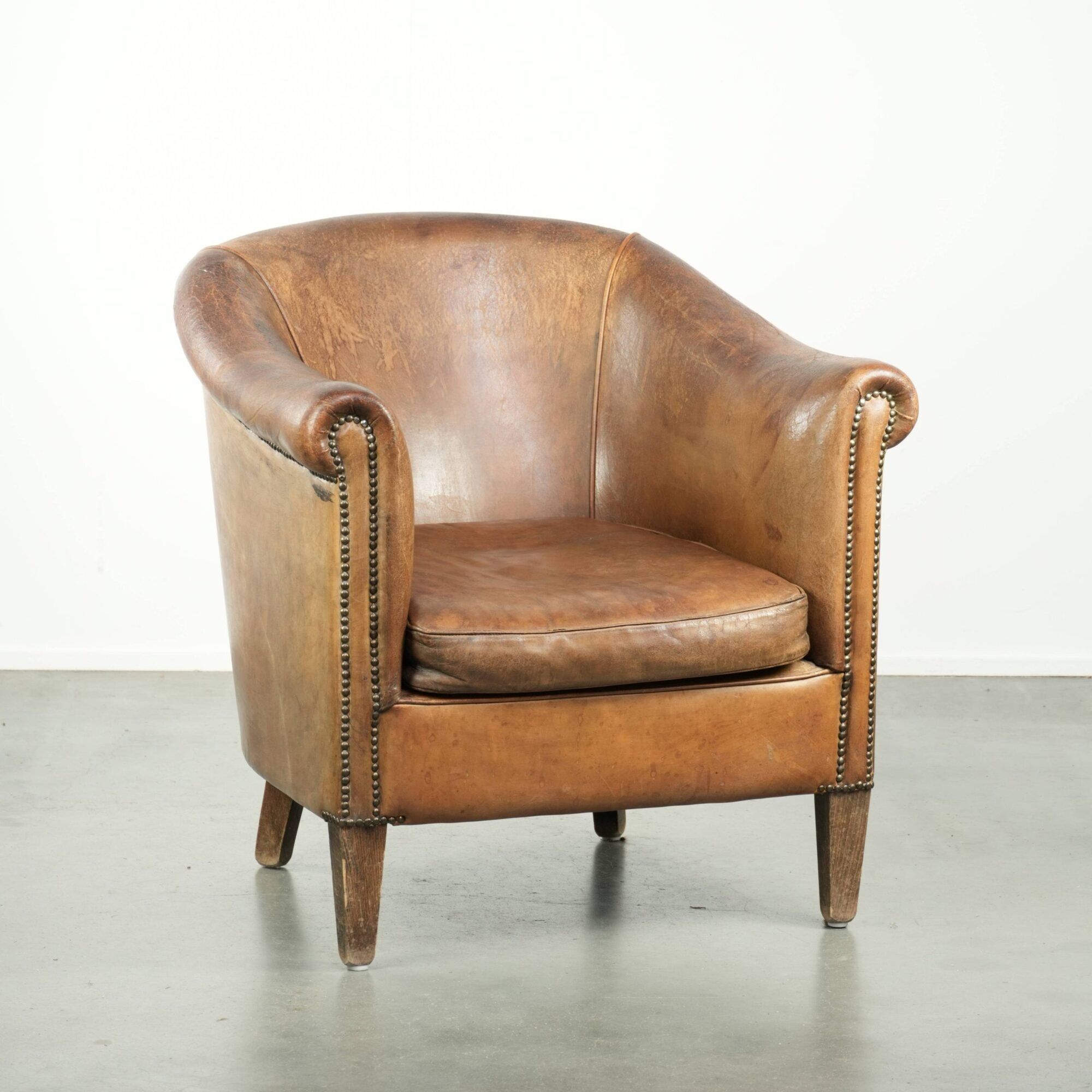 Vintage sheepskin club armchair finished with decorative nails