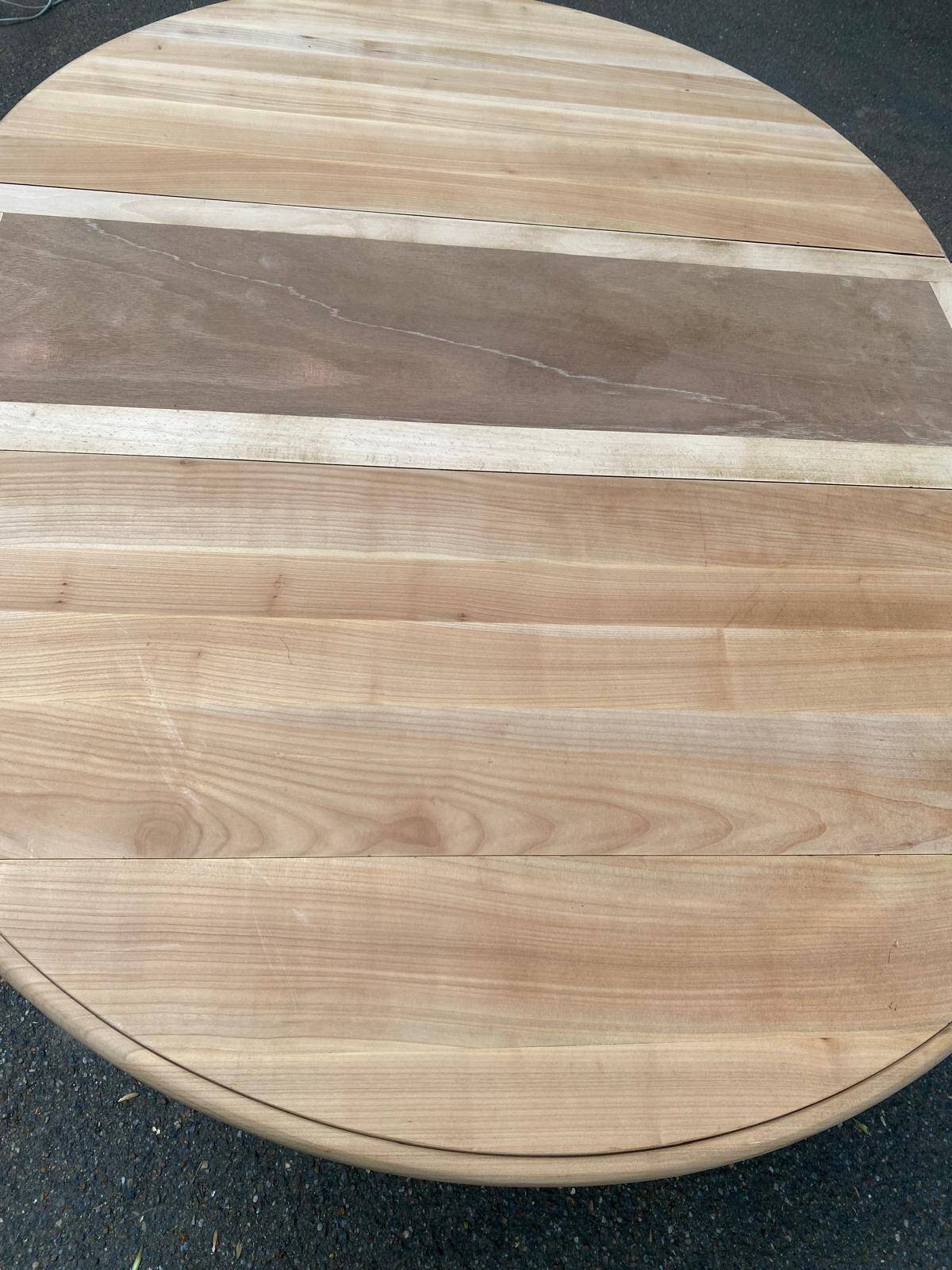 Round dining table with a central pedestal, extendable, stripped in solid walnut with 2 extensions.