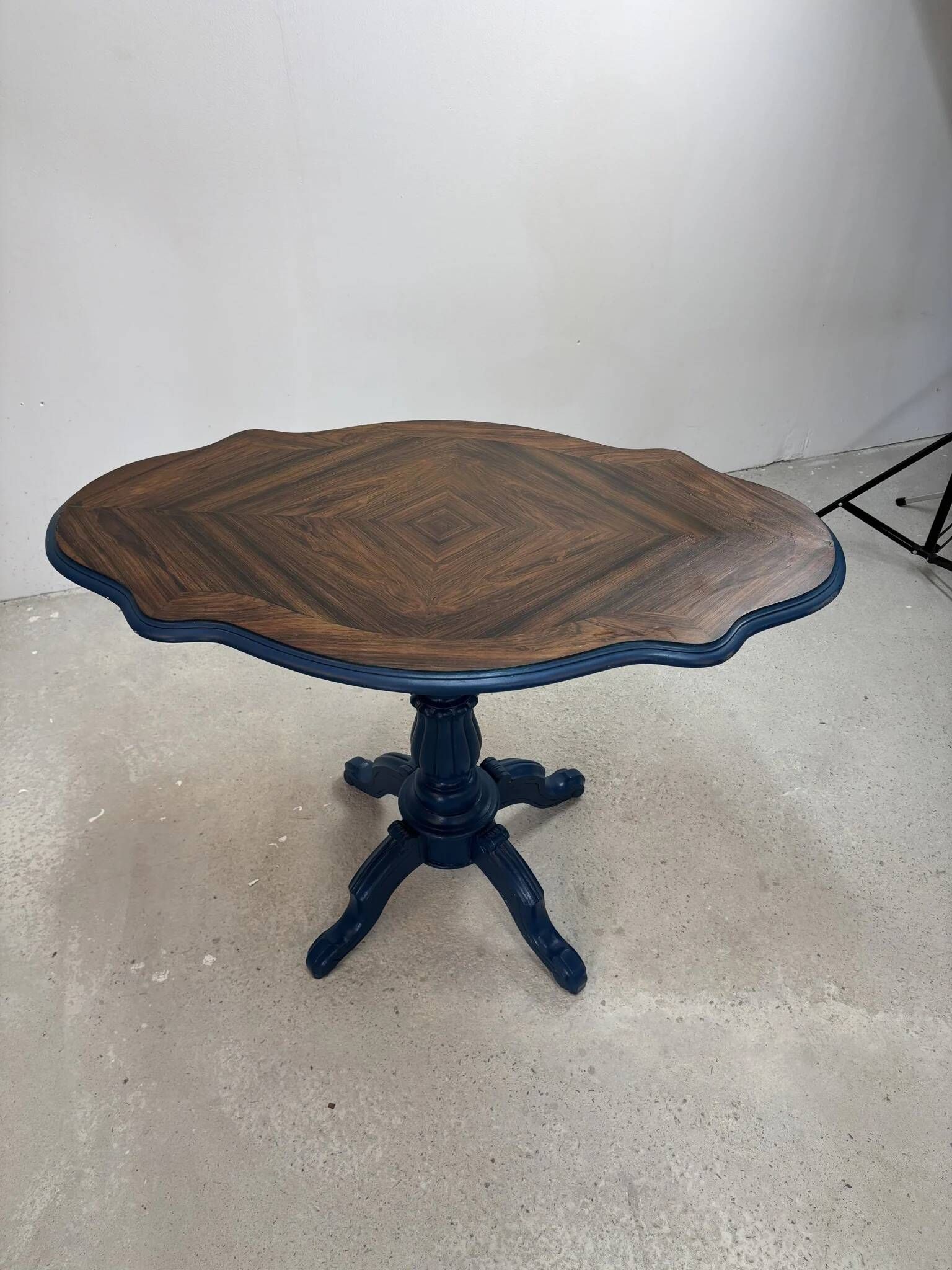 Wooden gueridon with a violin-shaped top in Rio rosewood, central base resting on four legs, reinterpreted in Baltic blue.