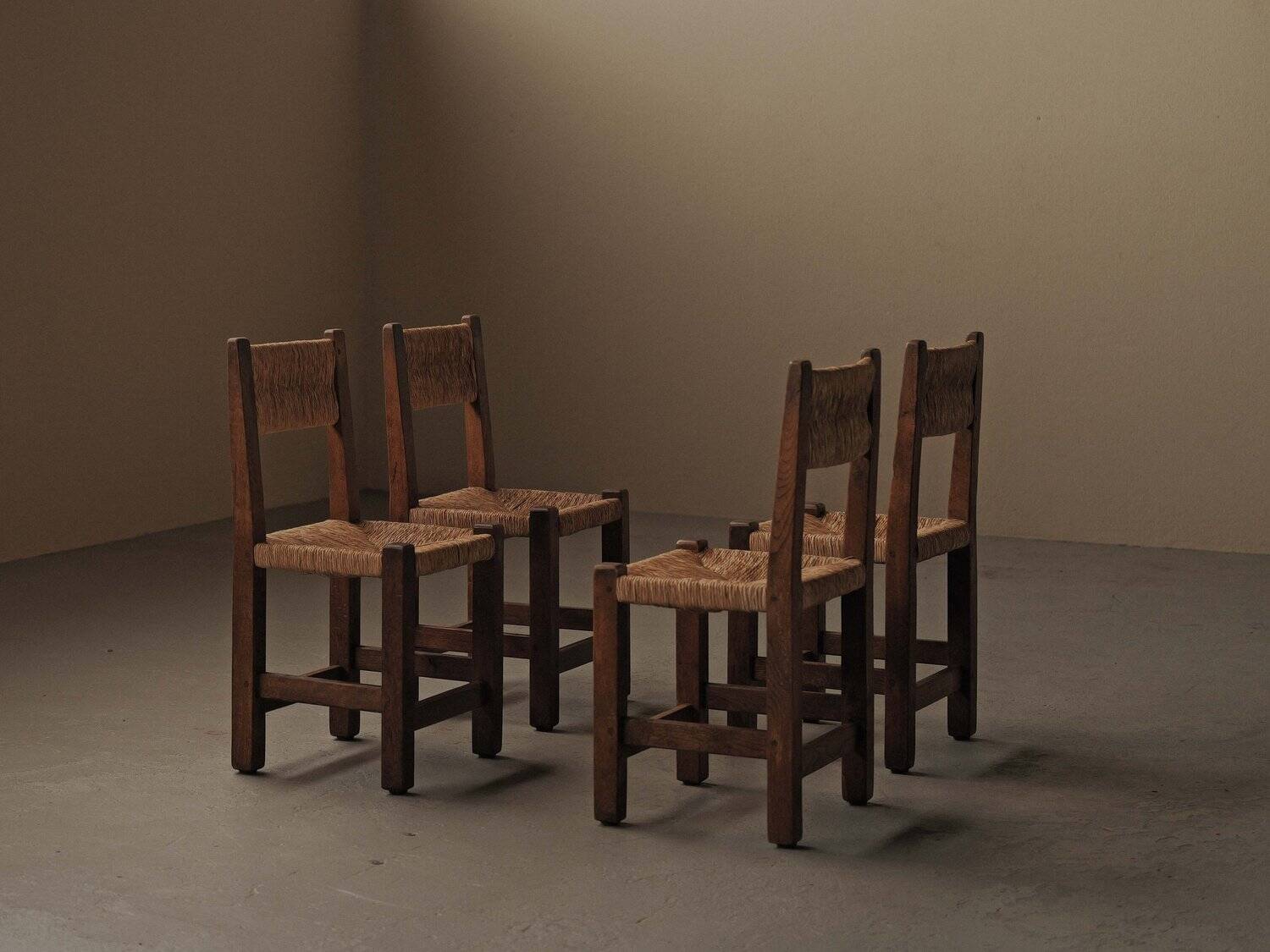 Set of four modernist chairs in oak and straw, France, circa 1960.