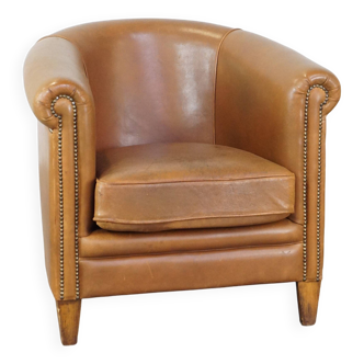 Fauteuil club en cuir de mouton de couleur cognac neutre et en bon état