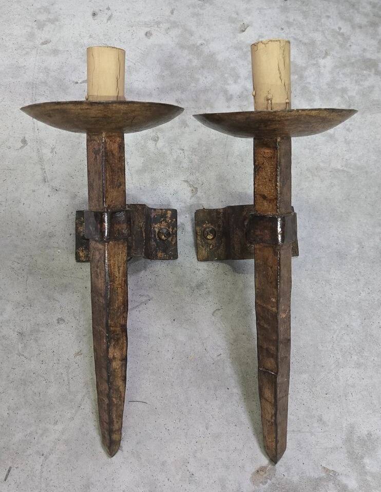 Pair of brutalist wall sconces in hammered and patinated iron, work from the years.
