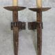Pair of brutalist wall sconces in hammered and patinated iron, work from the years.