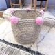 Moroccan basket with pale pink pompoms made of palm fiber