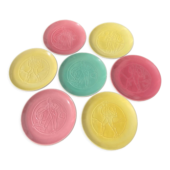 7 assiettes en céramique de Nyon à décor de personnages rose jaune et verte