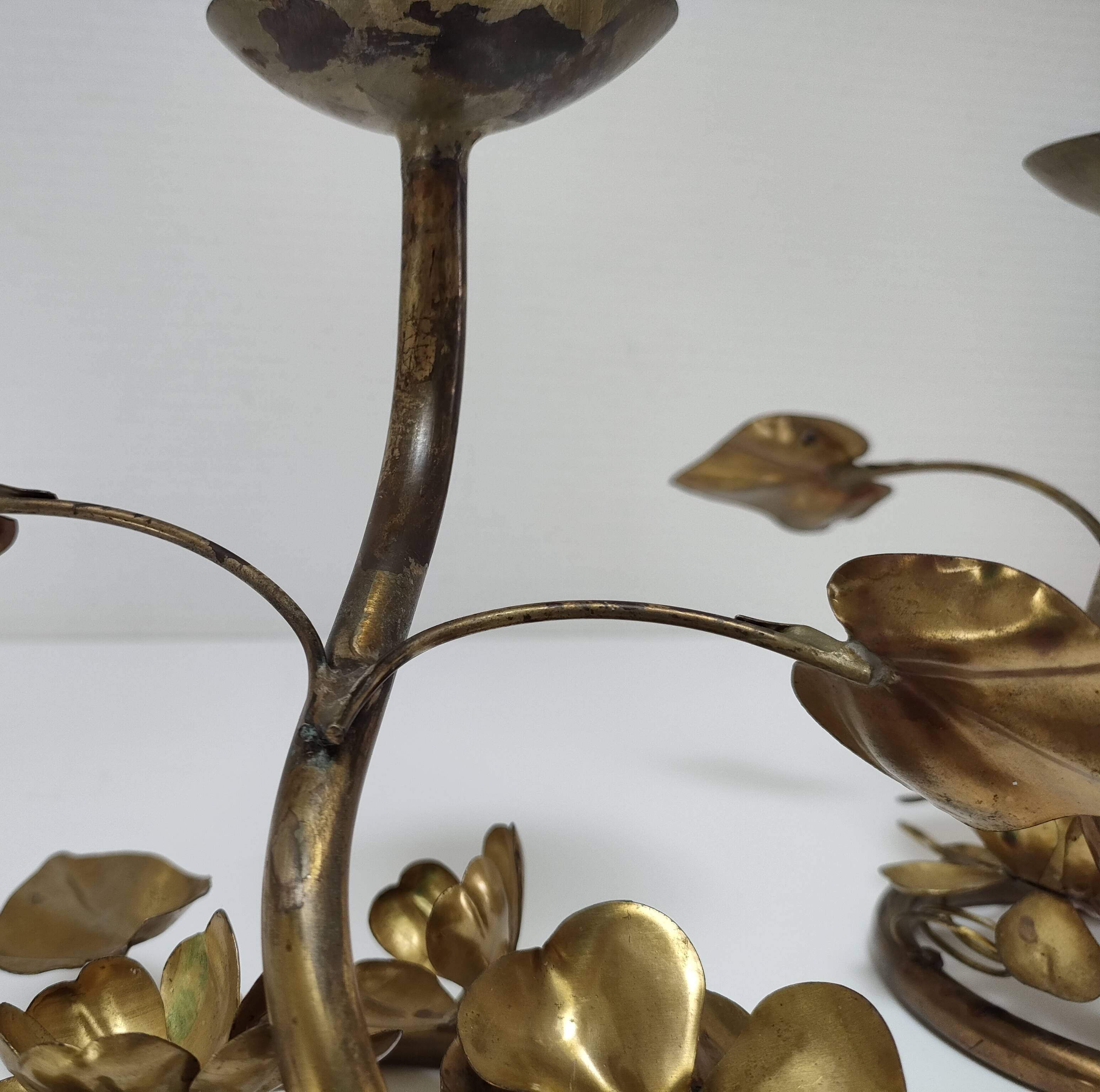 Pair of brass candle holders decorated with patinated metal flowers
