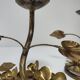Pair of brass candle holders decorated with patinated metal flowers