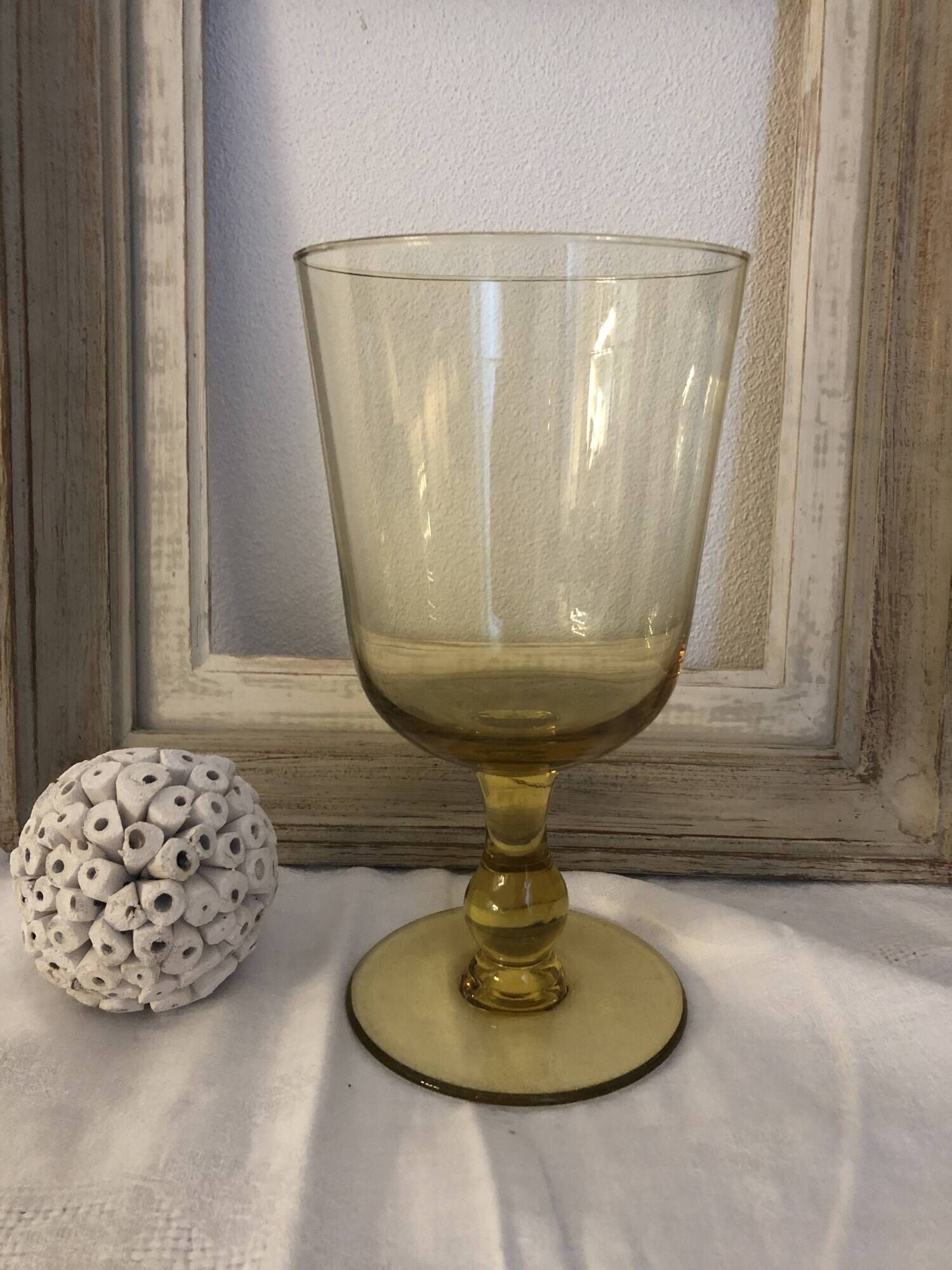 Yellow chalice vase, yellow glass vase on a pedestal.