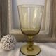 Yellow chalice vase, yellow glass vase on a pedestal.