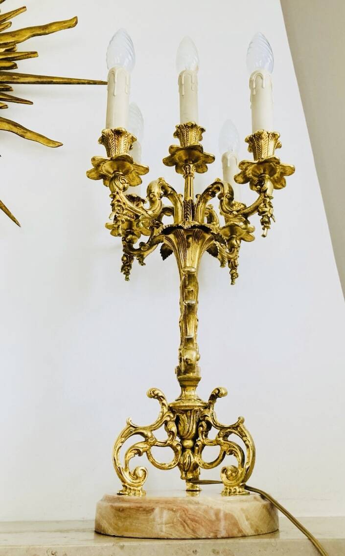 Massive gilded bronze chandeliers from the mid-20th century with marble bases.