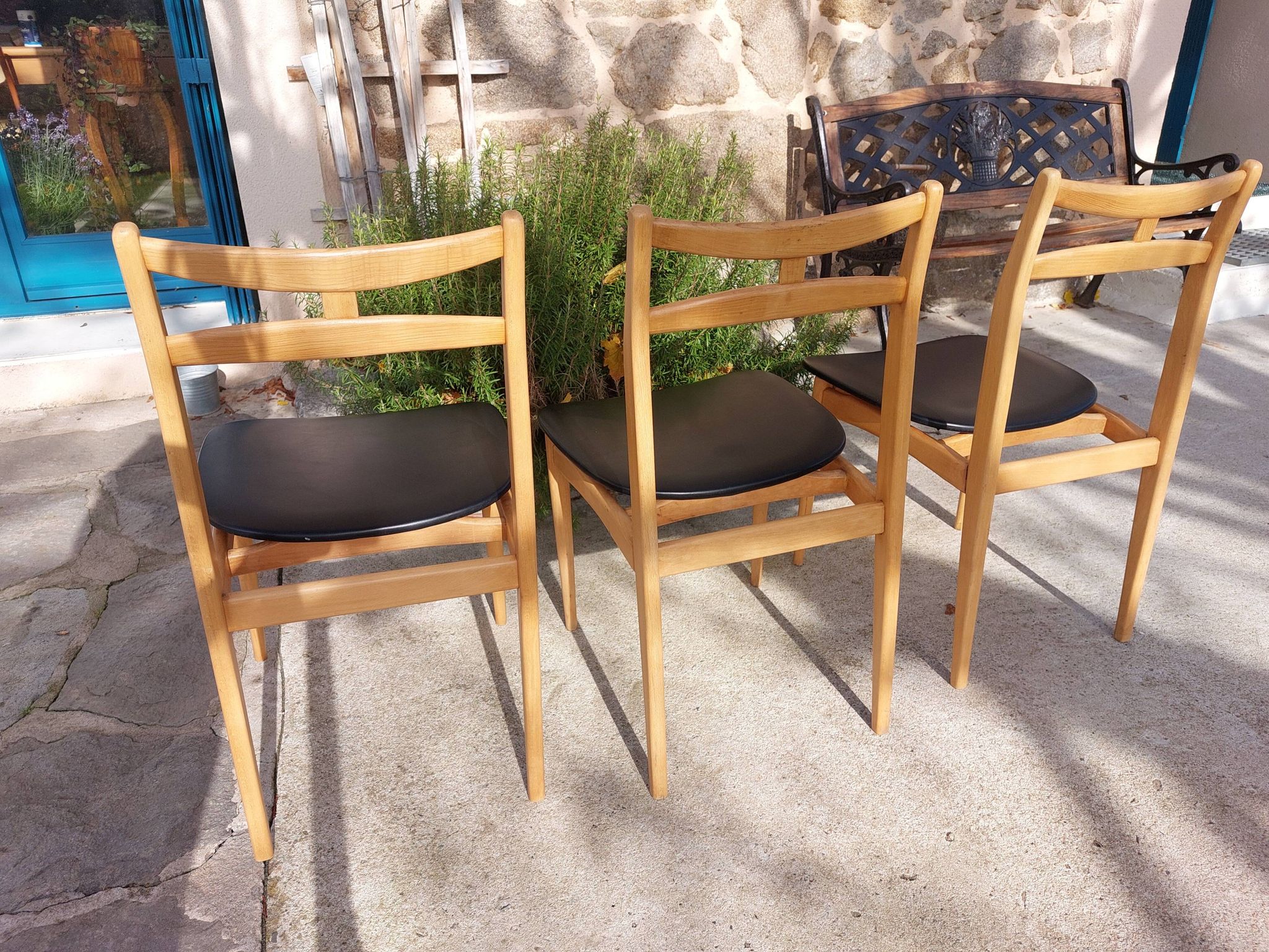 3 Scandinavian style chairs, light wood and black faux leather.