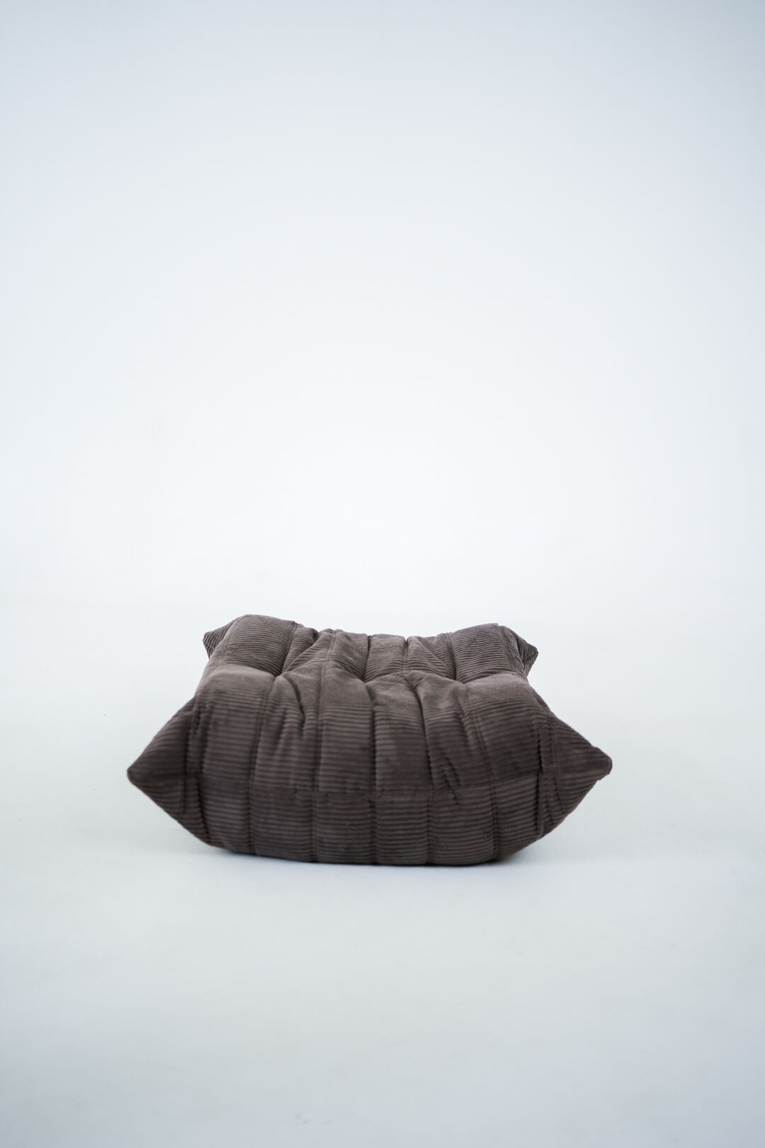 Ensemble de chaise et pouf Togo en velours côtelé marron.
