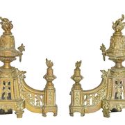 Pair of gilded brass fire dogs decorated with fire pots in the Louis XVI style.