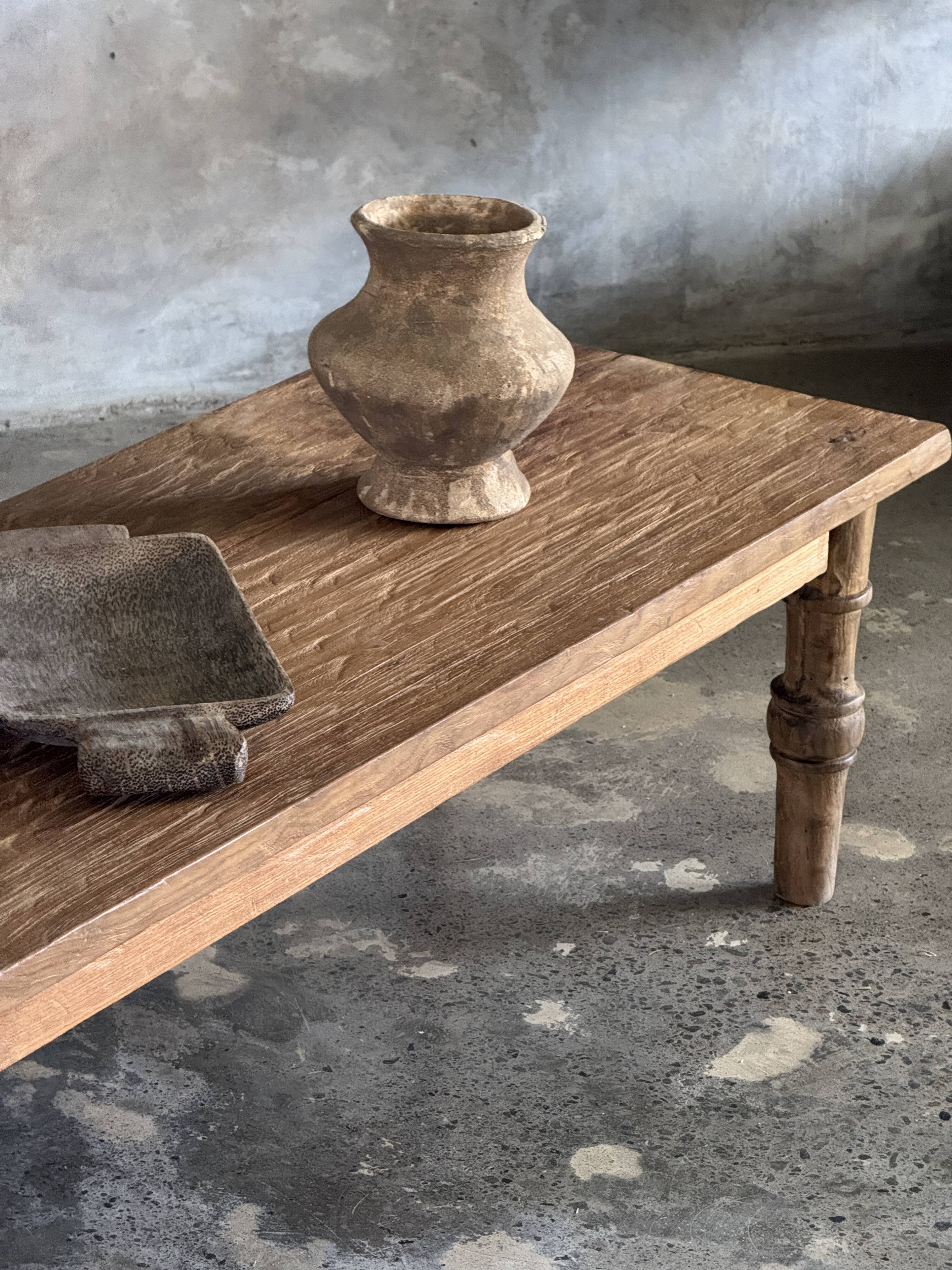 Brown Indonesian teak coffee table, with a border and cylindrical legs H40 L103.