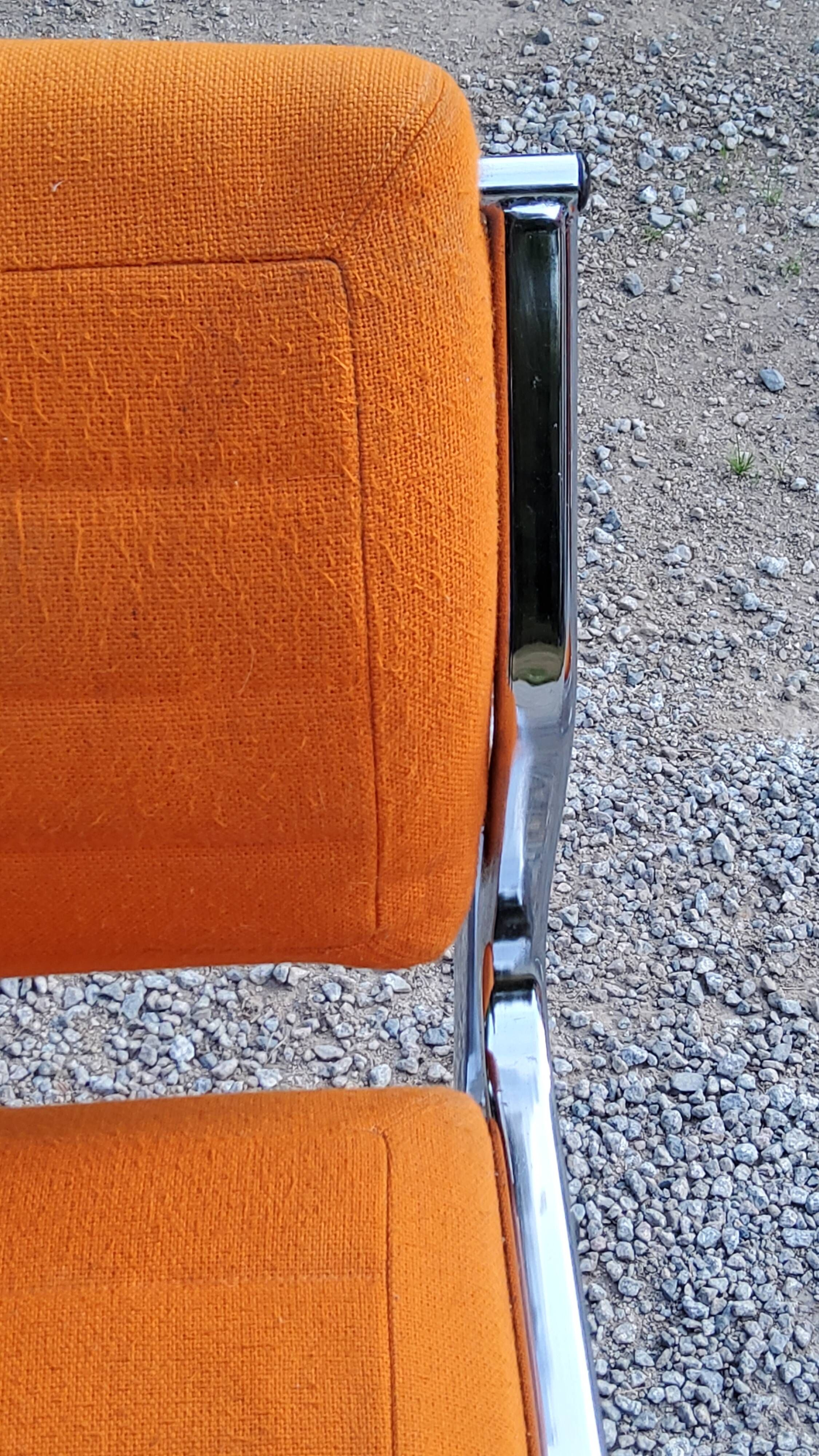 Pair of designer armchairs in orange fabrics and chrome tubes from the 70s