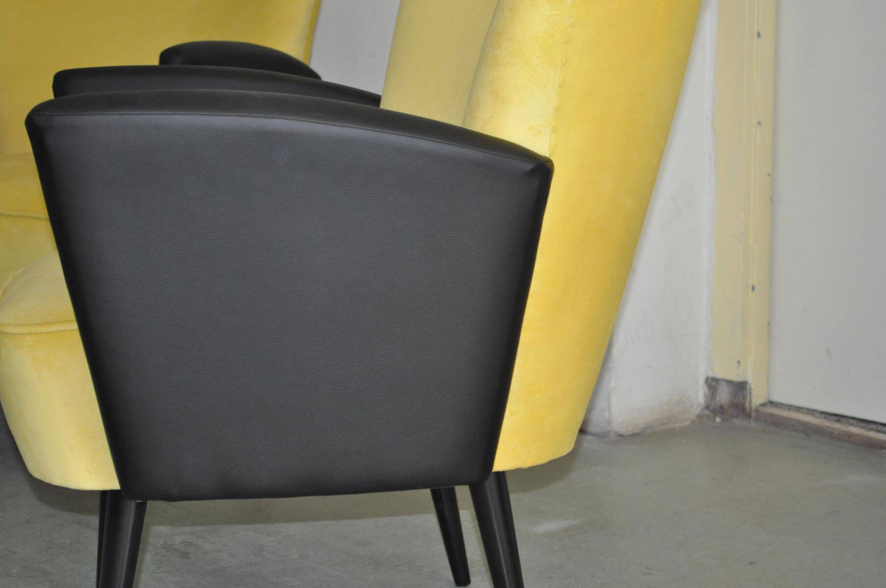 Pair of vintage 1950s cocktail chairs in yellow velvet and black faux leather, wooden frame.