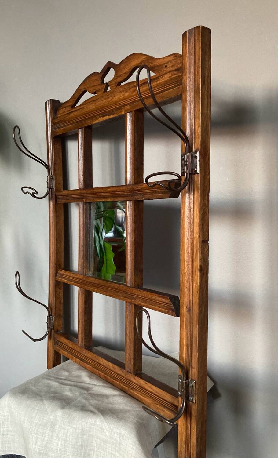Art Deco wall-mounted coat rack in oak, early 20th century. Beveled central mirror