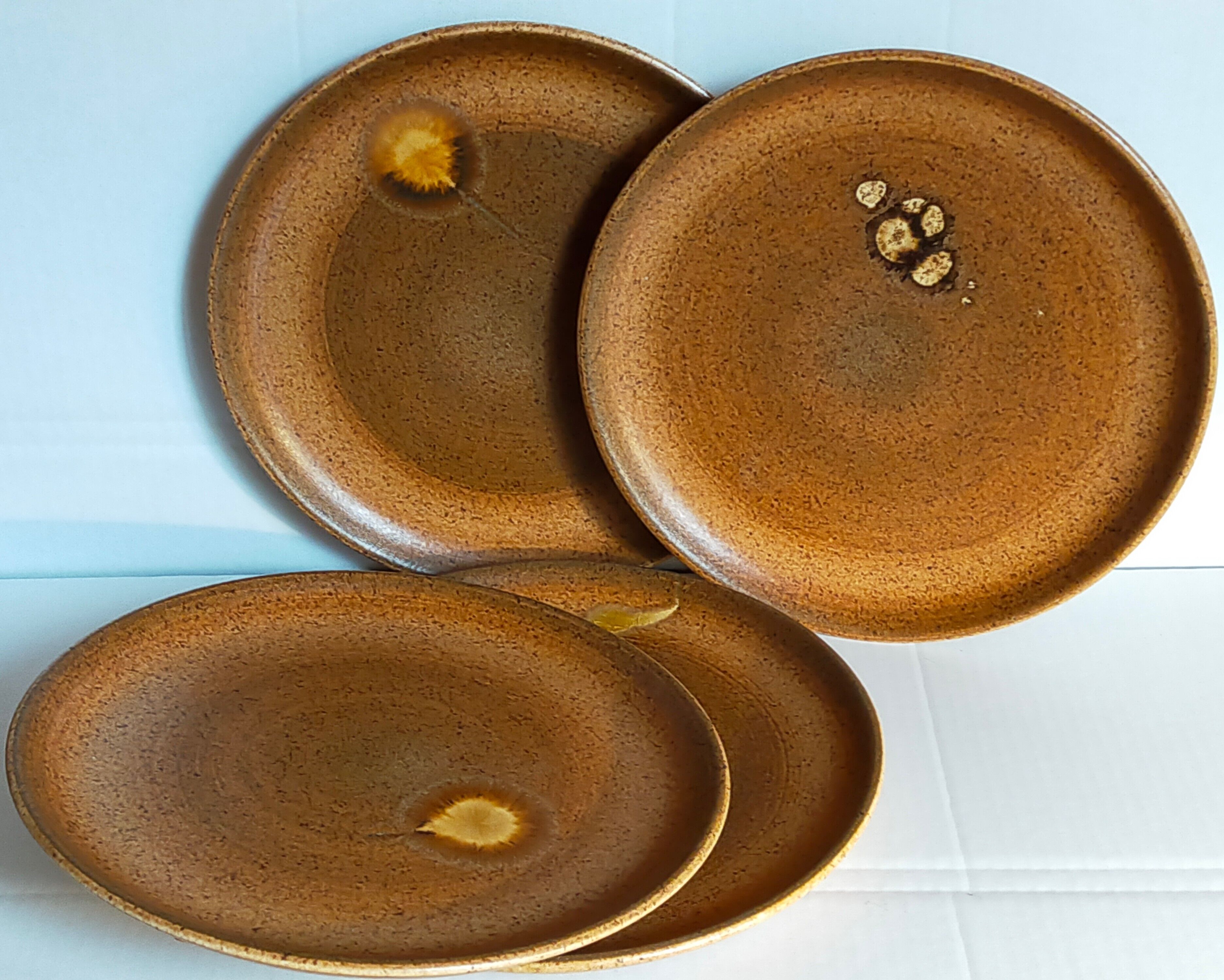 Four vintage glazed stoneware potter's plates
