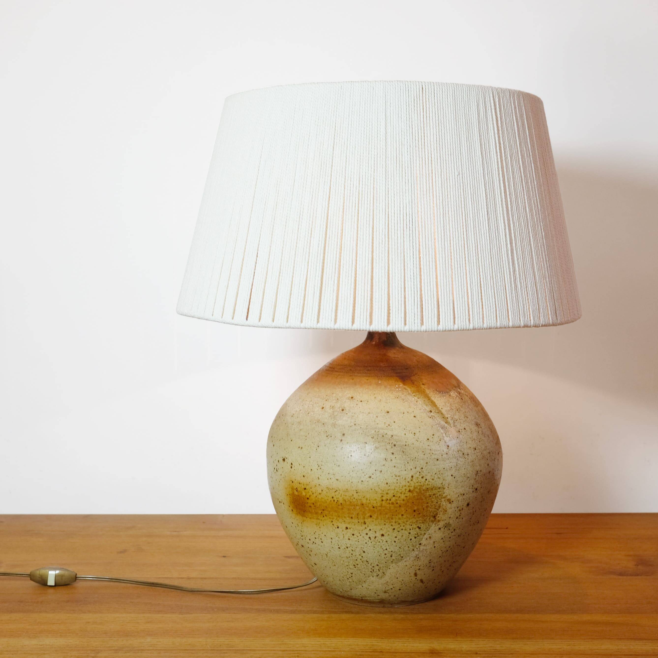 Large stone lamp with a cotton shade.