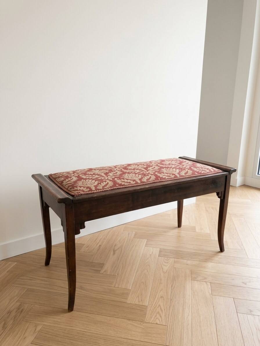 Antique wooden storage bench with red fabric.