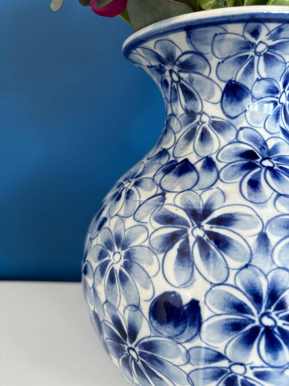 Blue and white ceramic vase with floral pattern in the shape of a vintage ball