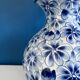 Blue and white ceramic vase with floral pattern in the shape of a vintage ball