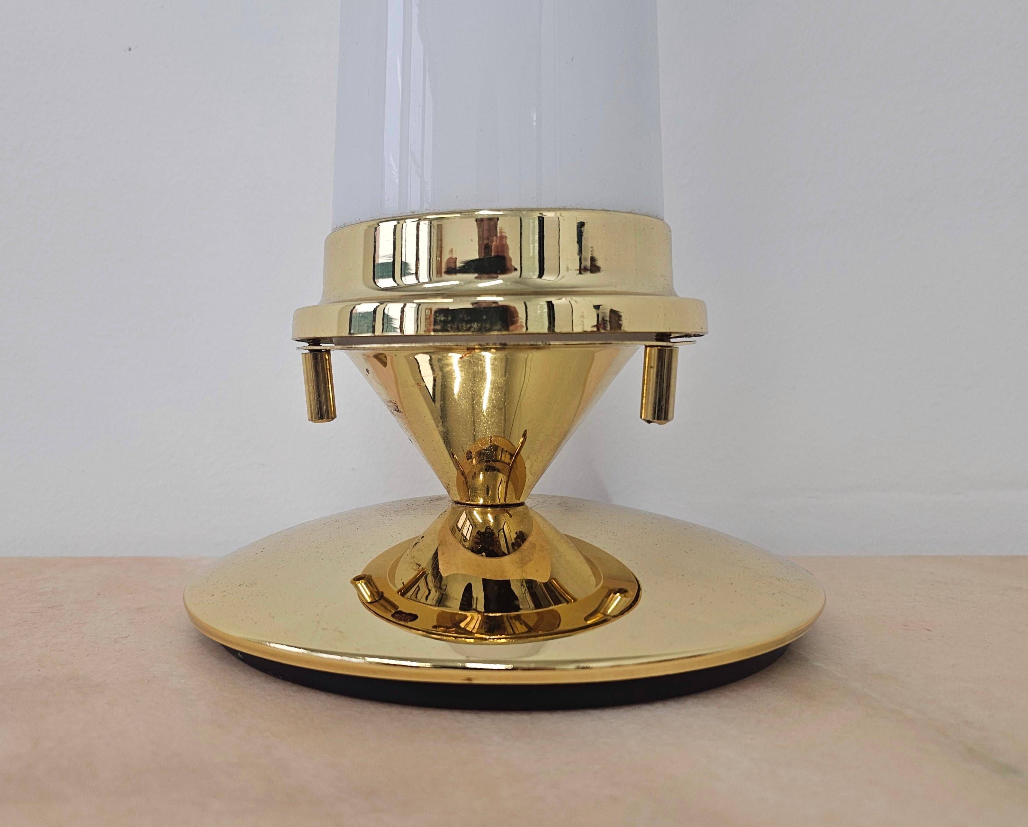 Pair of Hollywood Regency table lamps in brass with glass shades.