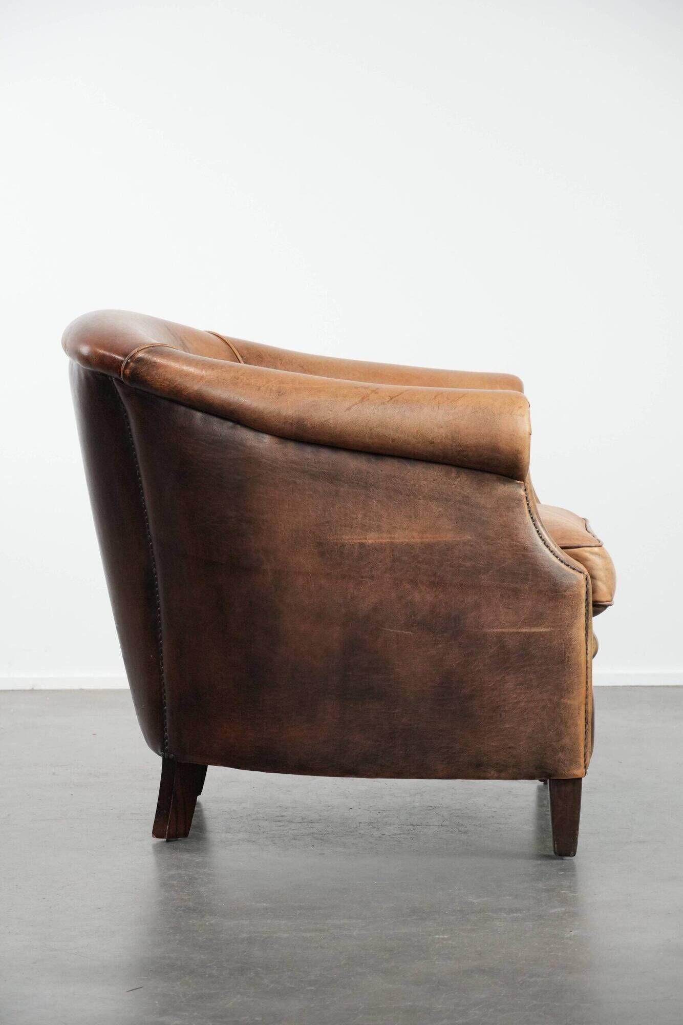 Club chair made of sheepskin leather finished with decorative nails