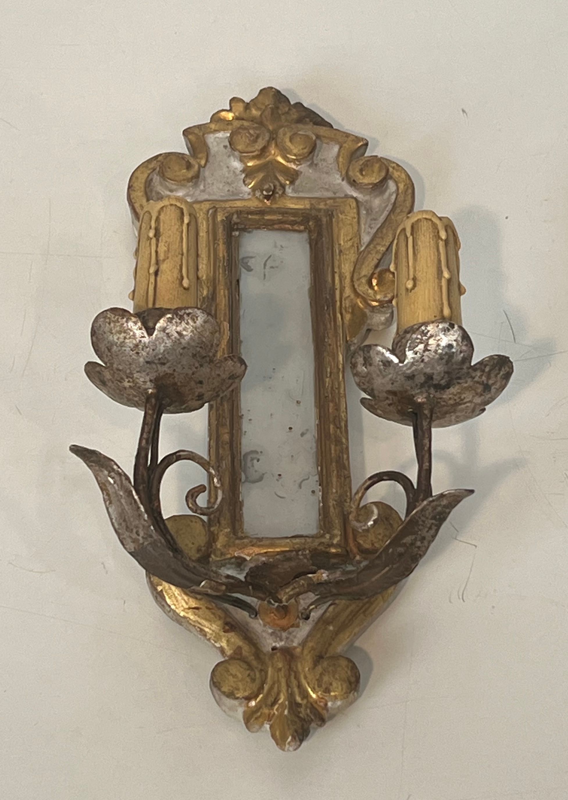 Pair of wall sconces in carved wood and silvered and gilded patinated metal with a central mirror.