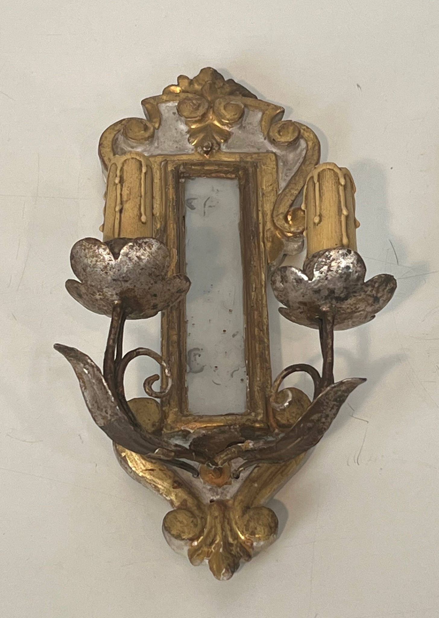 Pair of wall sconces in carved wood and silvered and gilded patinated metal with a central mirror.