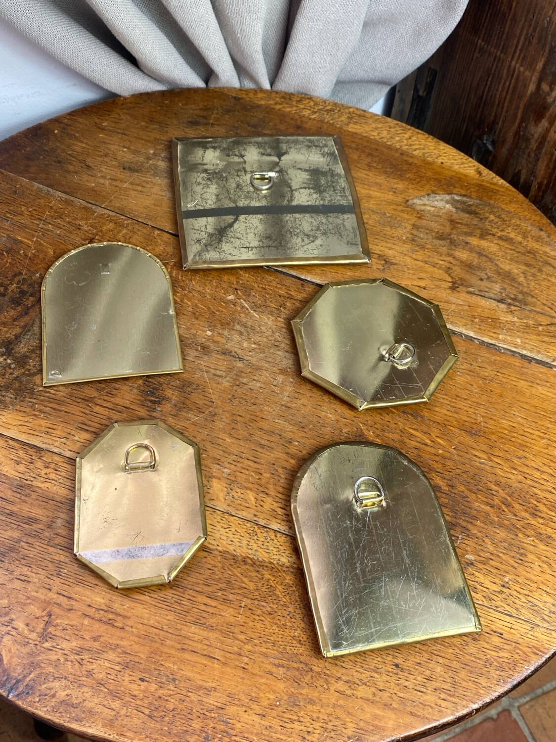 Set of five small wall mirrors in brass.