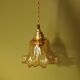 Amber tulip glass portable lamp, golden braided cord.