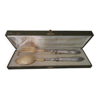 Silver salad servers stuffed in its case