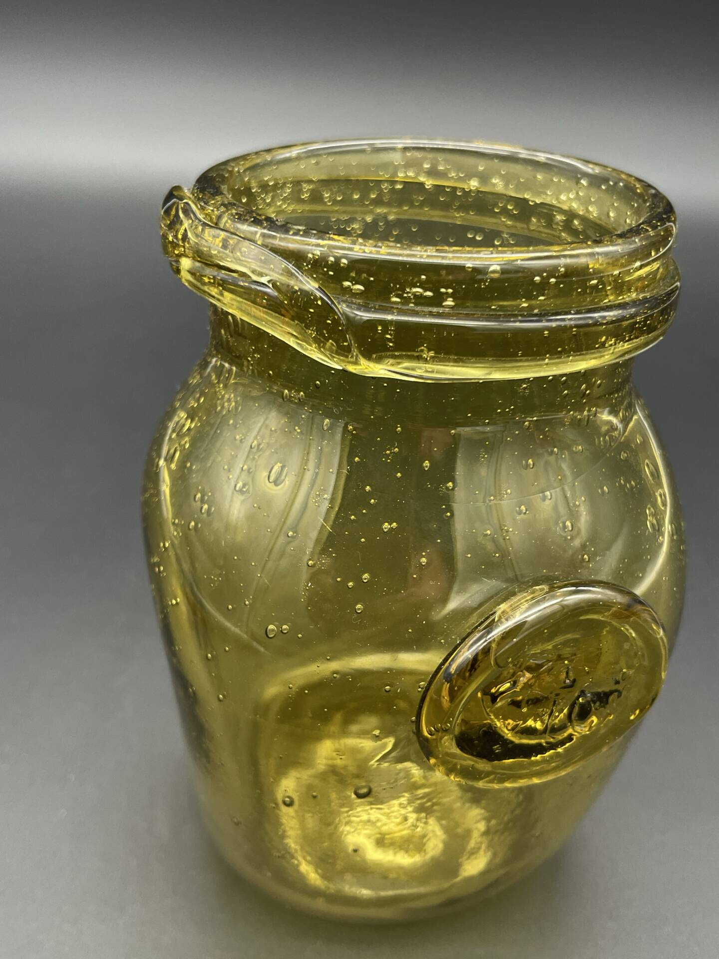 Yellow bubbled glass apothecary jar with cork lid.