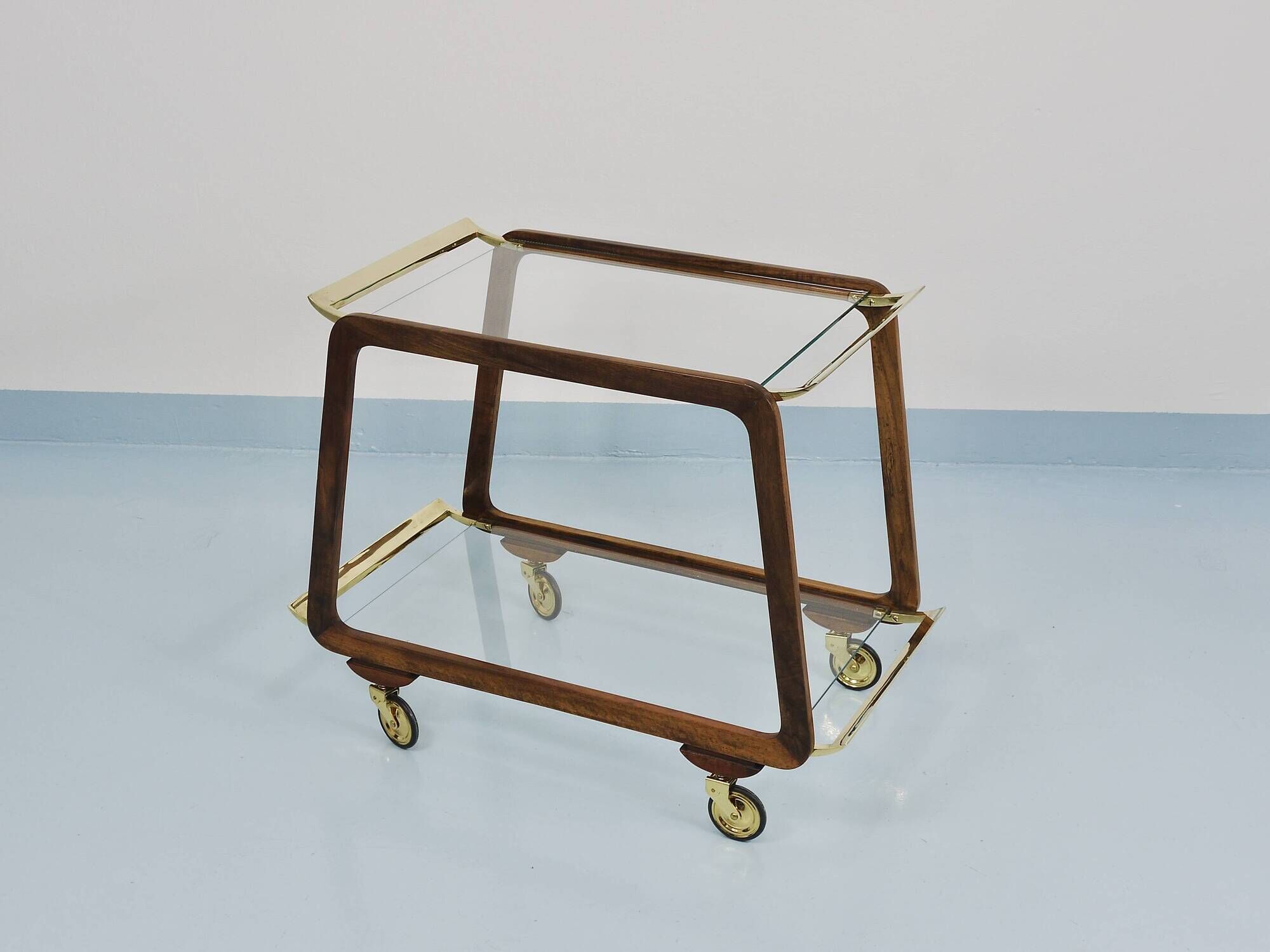 May include: A mid-century modern bar cart with a dark wood frame and two c