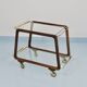 May include: A mid-century modern bar cart with a dark wood frame and two c