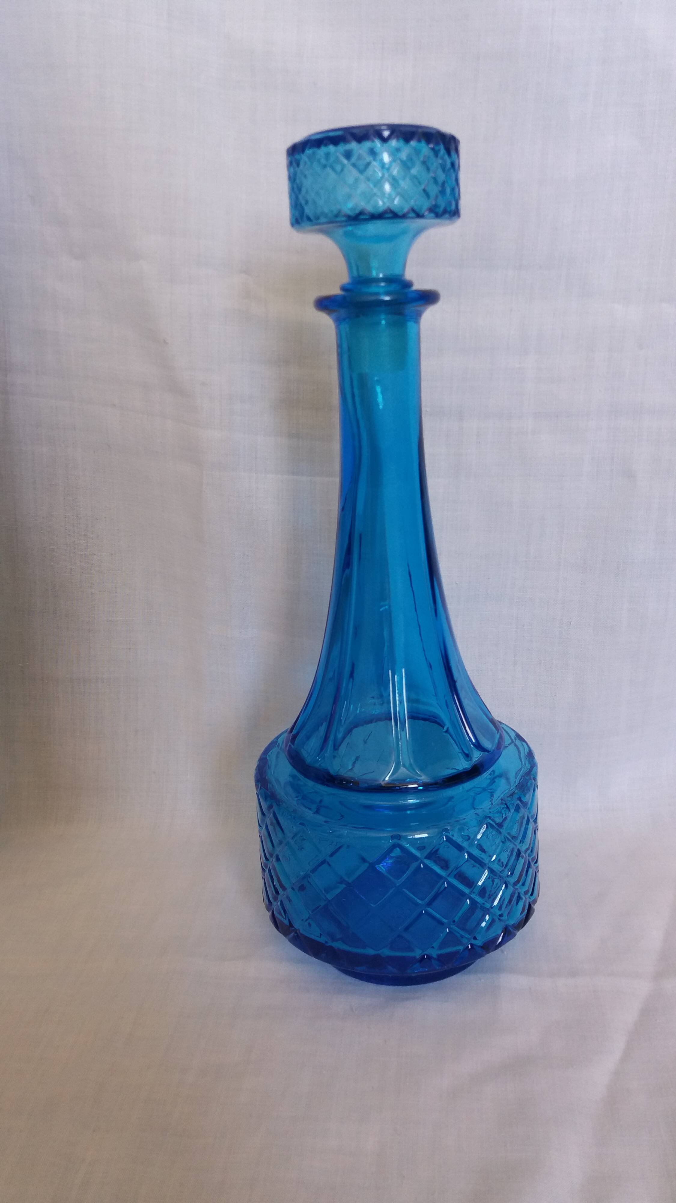 Turquoise glass carafe bottle with a stopper.