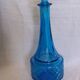 Turquoise glass carafe bottle with a stopper.