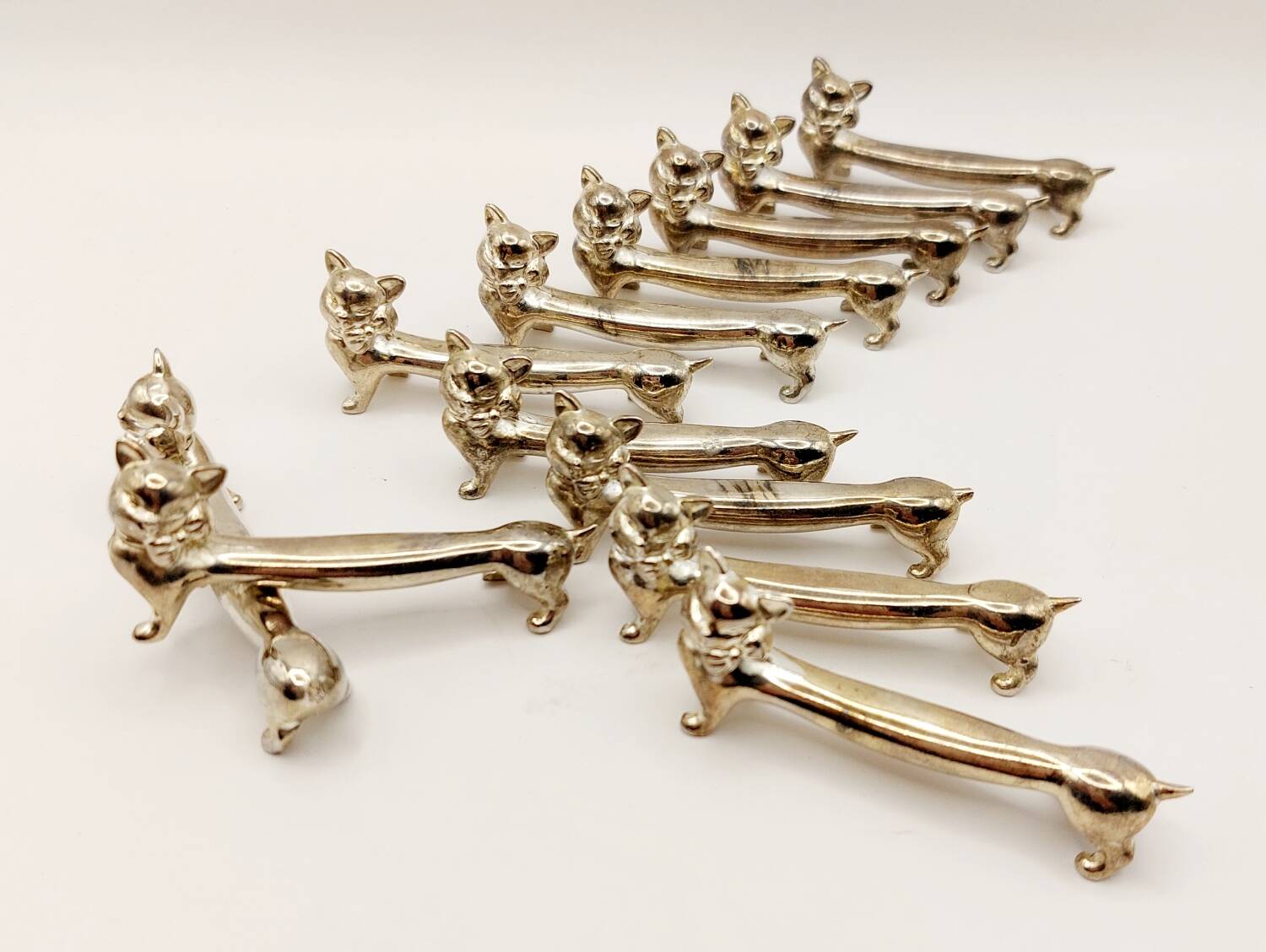 12 vintage silver metal cat knot knife rests