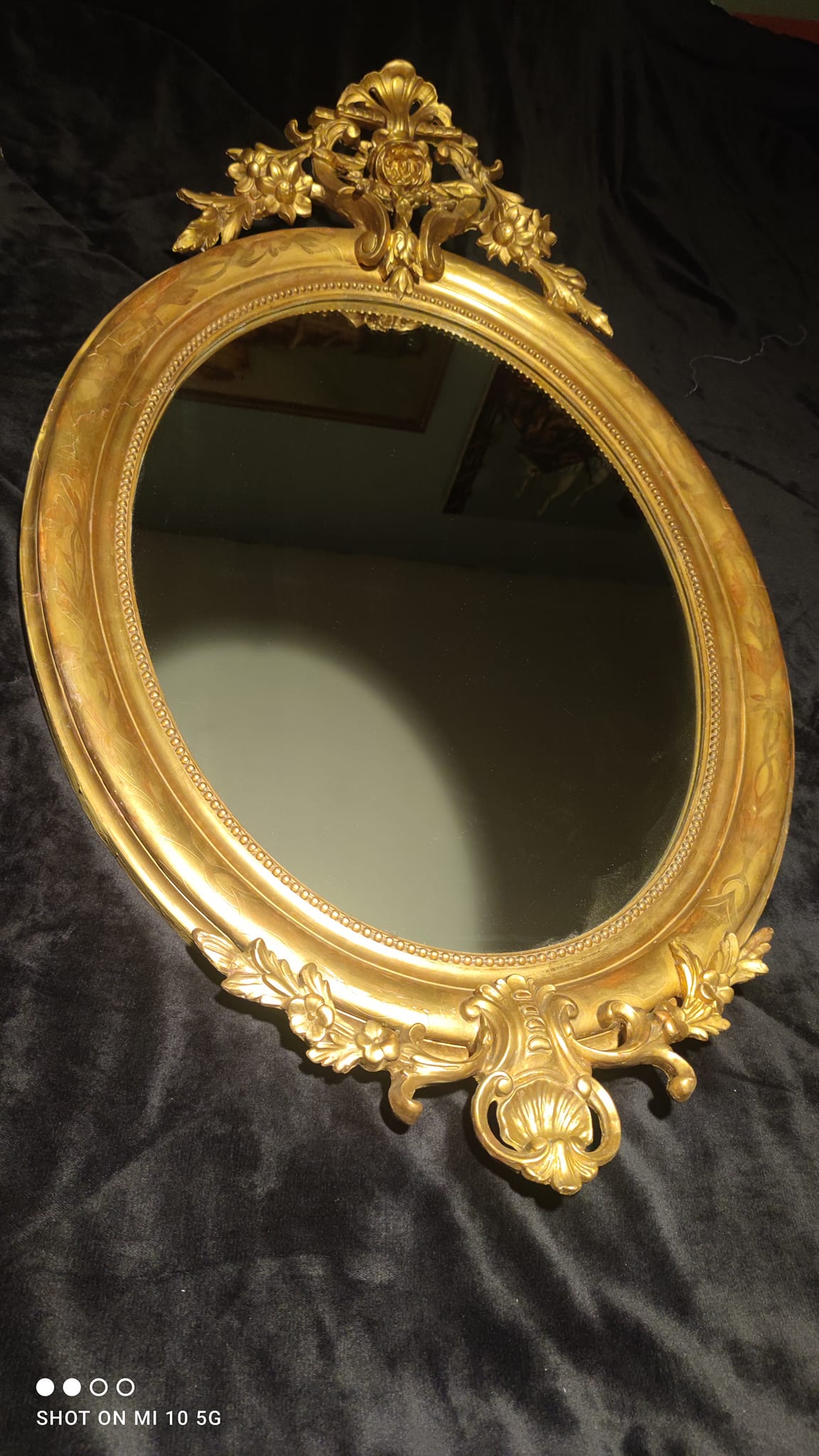 Ovoid mirror with double gilt pediments, circa 1830, 105x66 cm
