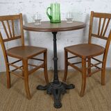 oak tray table with cast iron legs and pair of bistro chairs
