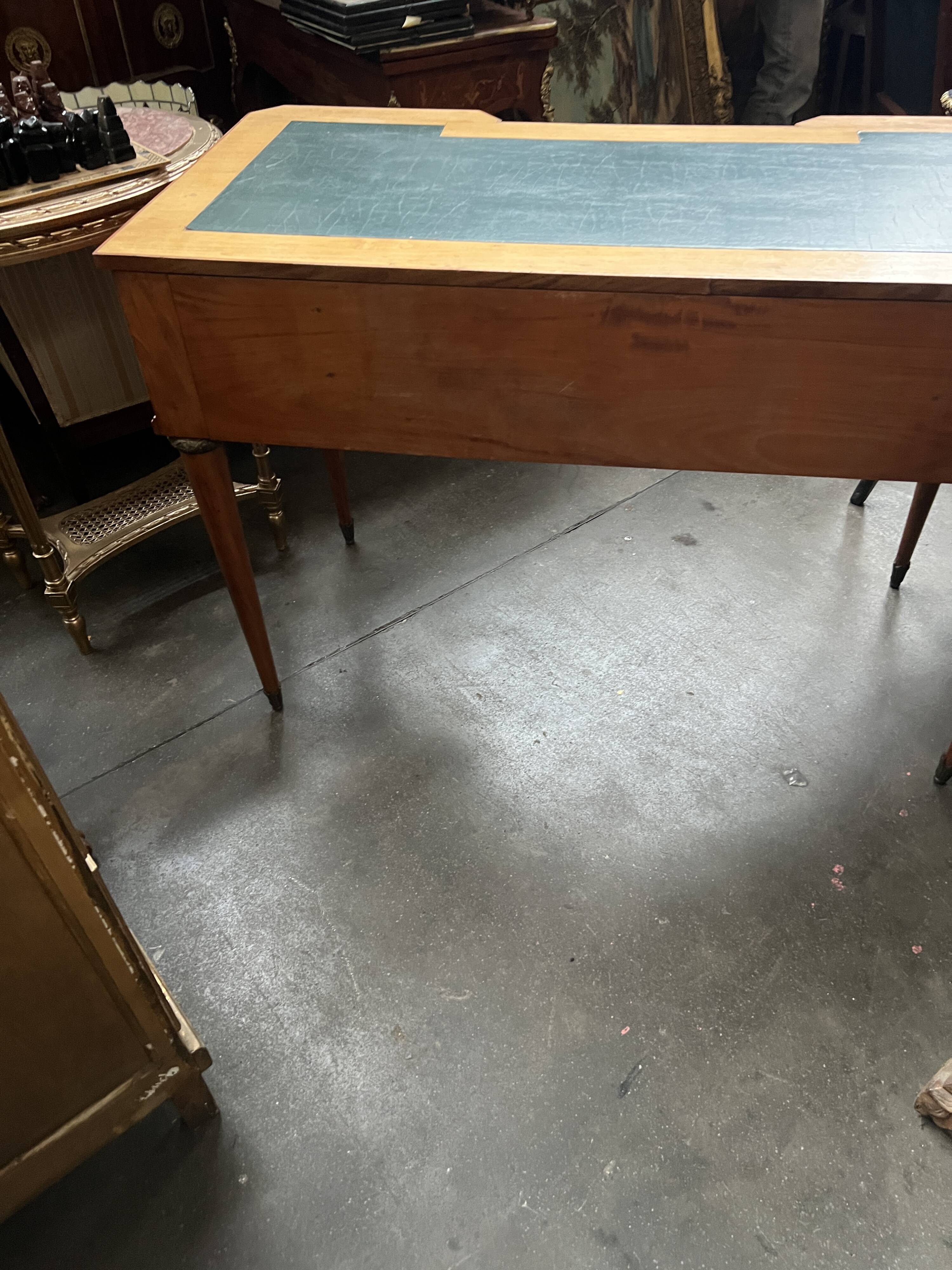 Louis XVI style marquetry desk. The top is decorated with green leather.