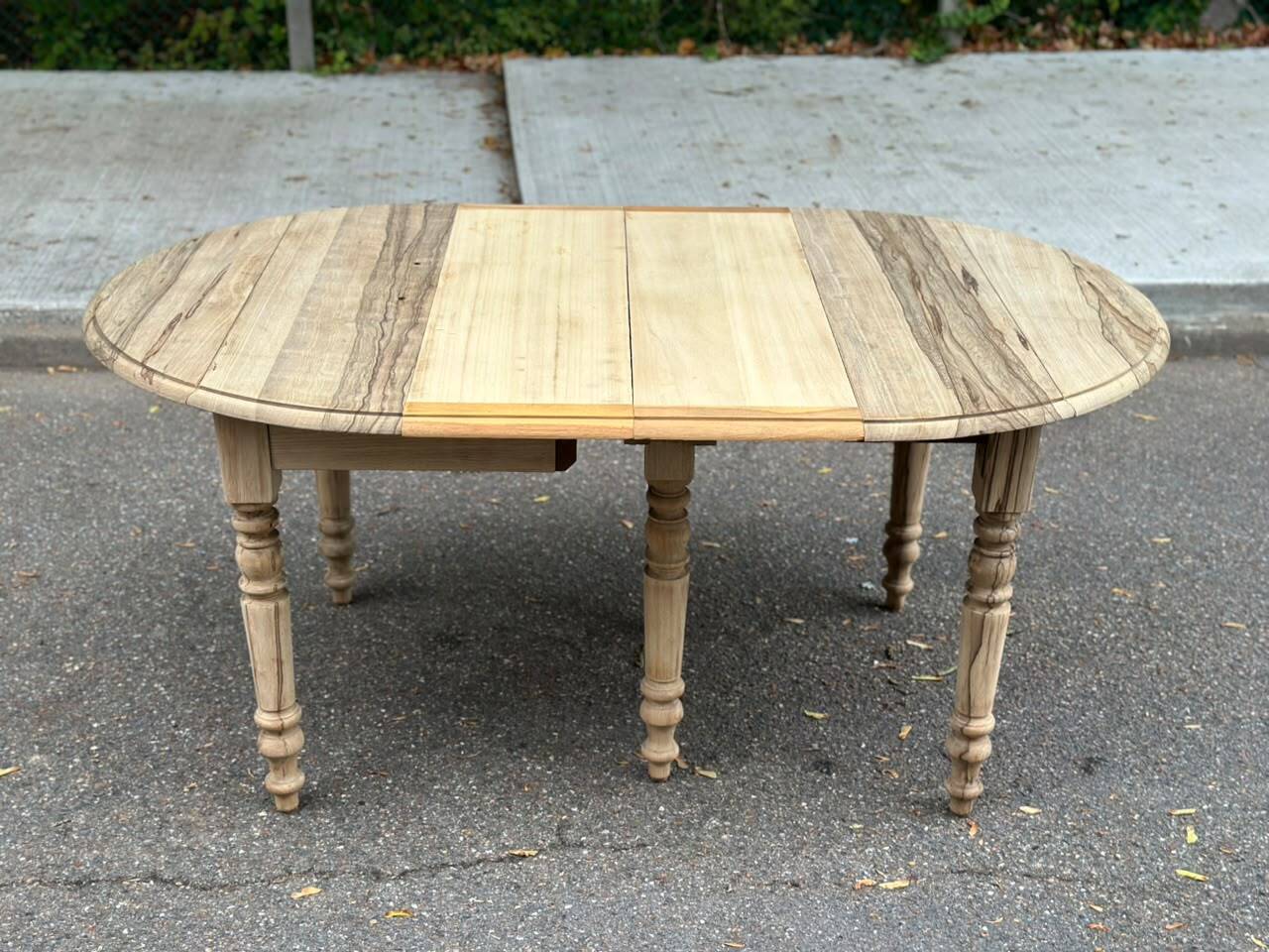 Round extendable dining table with flaps, stripped in raw oak, with 4 extensions.
