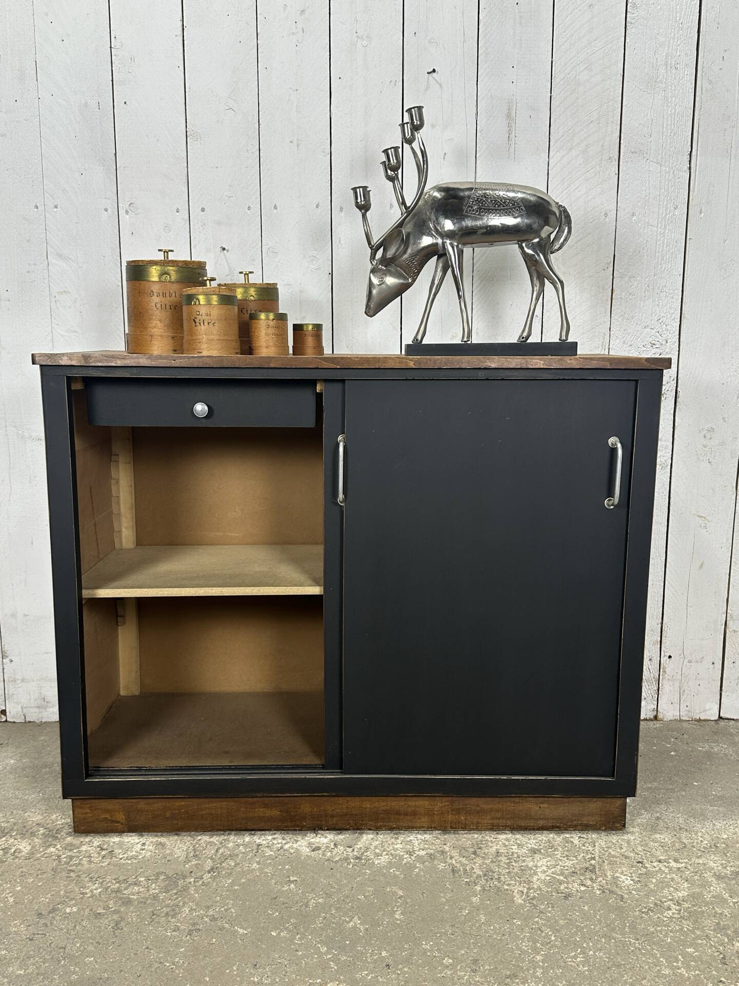 Small vintage black buffet with sliding doors.