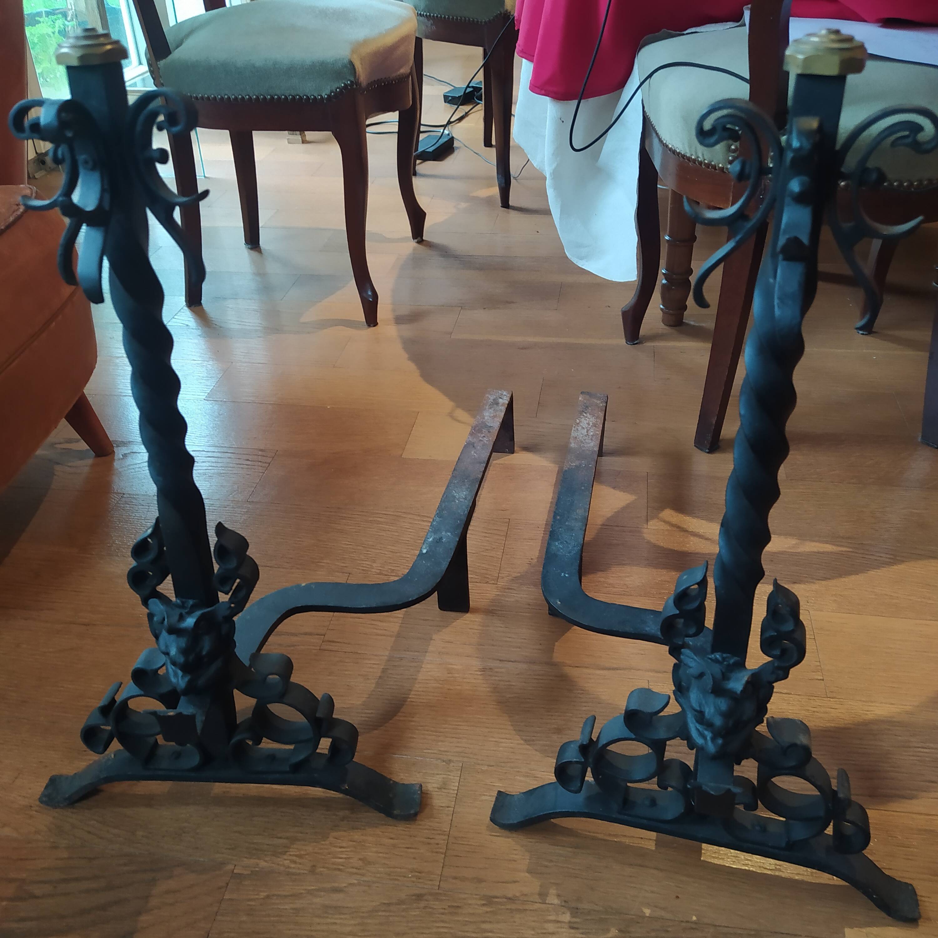 pair of large 20th century metal andirons with mascaron decoration